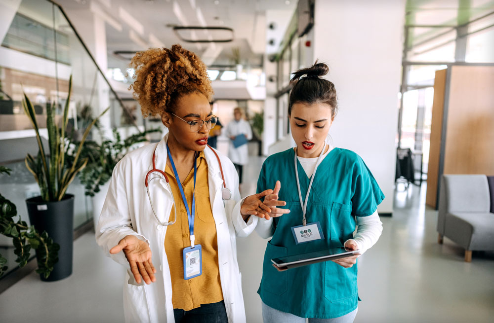 two nurses talking in hospital hallway