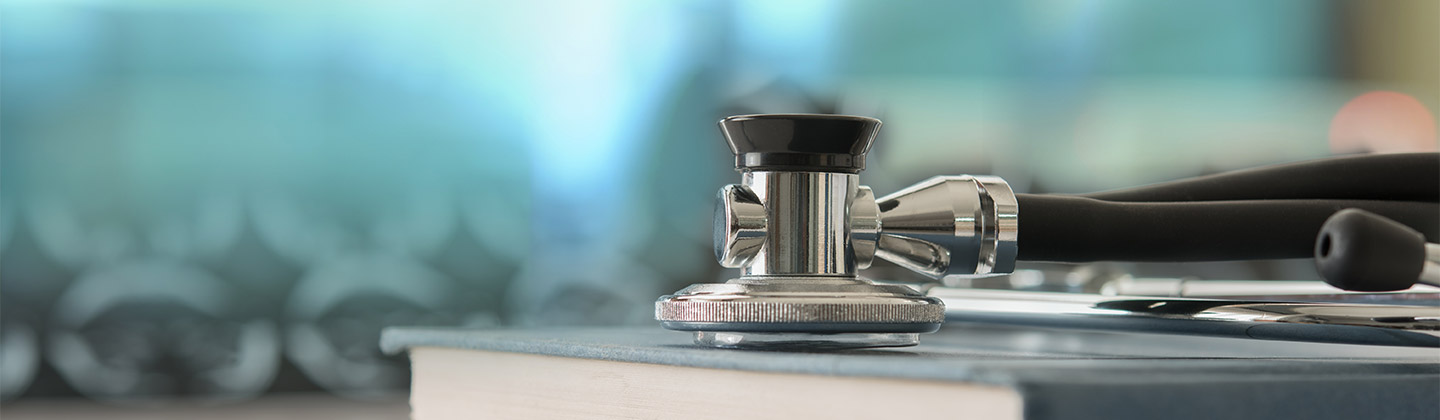 Stethoscope with medical text book on doctor student desk at classroom in the hospital.